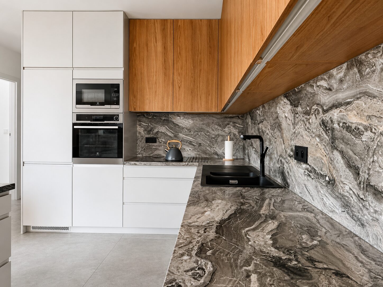 Modern minimalist kitchen with white cabinetry, wooden upper cabinets, grey marble countertop and black sink.